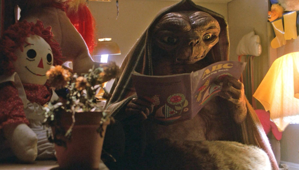 E.T. legge un fumetto in una scena di E.T. (1982) di Steven Spielberg